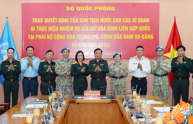 Thượng tướng Hoàng Xuân Chiến, Thứ trưởng Bộ Quốc phòng, đại biểu các cơ quan Bộ Quốc phòng và các sỹ quan nhận Quyết định của Chủ tịch nước tại buổi lễ. (Ảnh: Trọng Đức/TTXVN) si quan gin giu hoa binh2.jpg