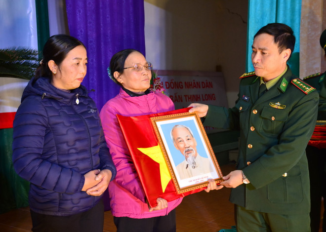 Trao cờ Tổ quốc và ảnh Bác Hồ cho ngư dân Nam Định. (Ảnh: Công Luật/Vietnam+) Tặng cờ Tổ quốc, ảnh Bác Hồ và phao cứu sinh cho ngư dân Nam Định ảnh 1