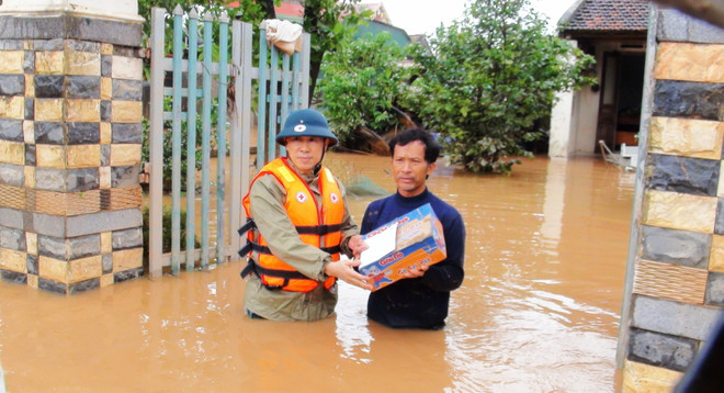 Mang những phần quà thiết thực đến tay người dân vùng lũ xã Hàm Ninh, huyện Quảng Ninh, Quảng Bình. (Ảnh: Võ Dung/TTXVN) Trung ương Hội Chữ thập đỏ Việt Nam tặng quà cứu trợ tại Quảng Bình ảnh 1