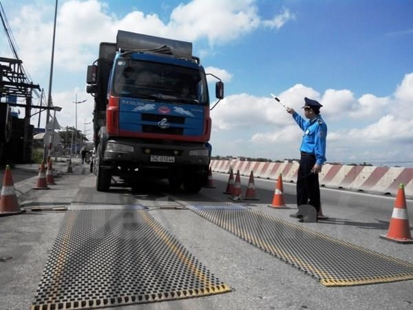 Lực lượng chức năng tiến hành kiểm tra tải trọng xe. Ảnh minh họa. (Ảnh: Việt Hùng/Vietnam+) Làm rõ tố giác lãnh đạo cảnh sát can thiệp không xử lý xe vi phạm ảnh 1