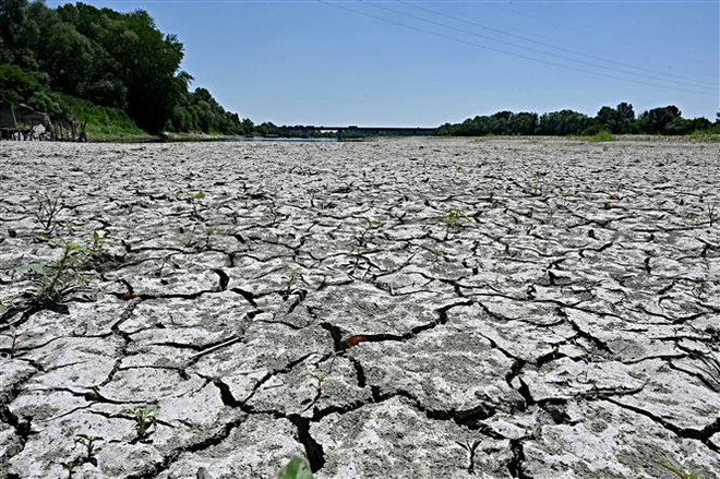 Lòng sông khô cạn do hạn hán tại Occhiobello, Italy, ngày 5/7/2022. (Ảnh: AFP/TTXVN) Trái Đất vẫn sẽ nóng lên bất chấp những nỗ lực trong nhiều năm qua? ảnh 1