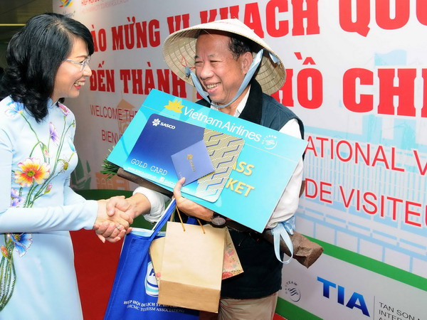 Bà Nguyễn Thị Thu, Phó Chủ tịch Ủy ban Nhân dân Thành phố chúc mừng ông Chappe Bertrand (Quốc tịch Pháp) là vị khách thứ 5 triệu đi trên chuyến bay VN10 từ Pháp đến Thành phố Hồ Chí Minh. (Ảnh: An Hiếu/TTXVN) Thành phố Hồ Chí Minh đã đón du khách quốc tế thứ 5 triệu ảnh 1