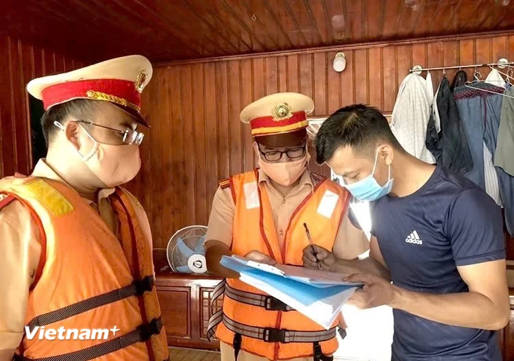 Lực lượng Cảnh sát giao thông đường thủy hướng dẫn các chủ phương tiện ký cam kết chấp hành nghiêm Luật Giao thông đường thủy. (Ảnh: Nguyễn Thảo/Vietnam+)