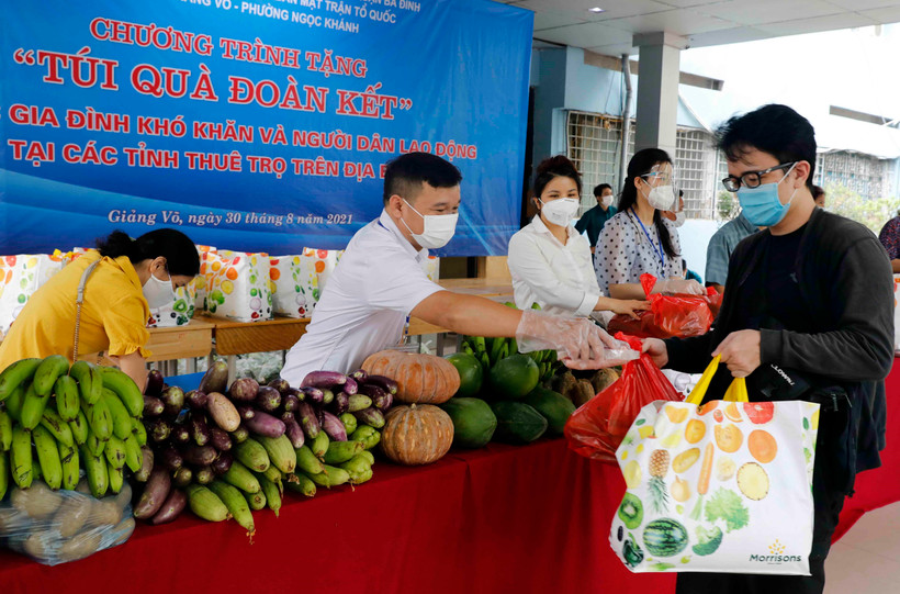 Cán bộ mặt trận tổ quốc trao “túi quà đoàn kết” cho những hộ nghèo, gia đình chính sách, người dân lao động ngoại tỉnh, sinh viên. (Ảnh: Trần Việt/TTXVN)