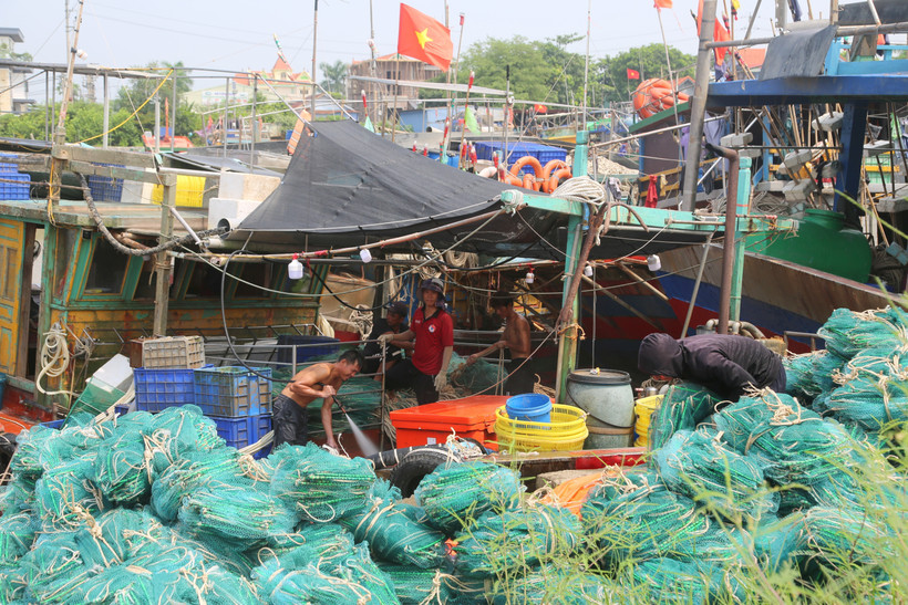 Ngư dân dọn dẹp tàu cá trước khi rời tàu về nhà tránh bão số 3. (Ảnh: Minh Thu/TTXVN)