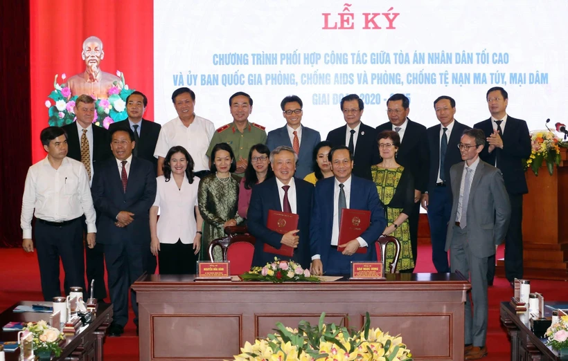 Bộ trưởng Bộ Lao động-Thương binh và Xã hội Đào Ngọc Dung và Chánh án Tòa án nhân dân tối cao Nguyễn Hòa Bình trao biên bản sau khi ký kết Chương trình phối hợp công tác. (Ảnh: Anh Tuấn/TTXVN)