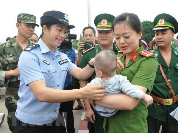 Lực lượng chức năng Việt Nam tiếp nhận em bé bị bán sang Trung Quốc. (Ảnh:Nguyễn Hoàng/TTXVN)
