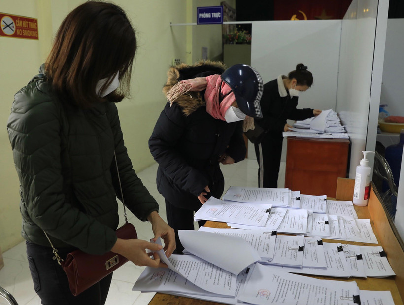 Người dân lấy giấy xác nhận F0 tại phường. (Ảnh: Hoàng Hiếu/TTXVN) 