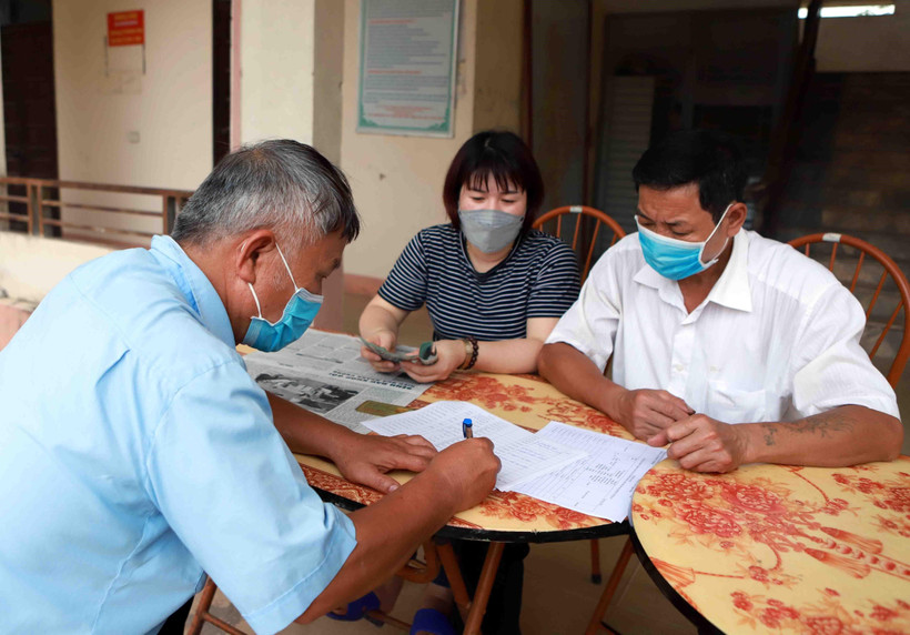 Chi trả tiền hỗ trợ cho người dân gặp khó khăn do COVID-19. (Ảnh: Hoàng Hùng/TTXVN)