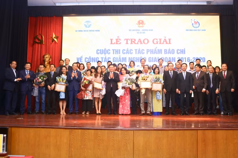 Trao giải cho các tác phẩm đạt giải báo chí viết về công tác giảm nghèo.(Ảnh: Minh Quyết/TTXVN)