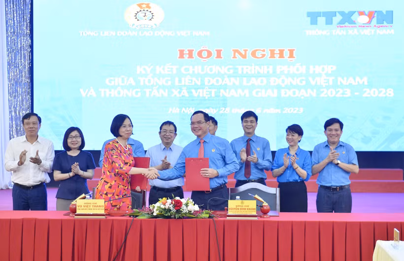 Tổng Giám đốc TTXVN Vũ Việt Trang và Chủ tịch Tổng Liên đoàn Lao động Việt Nam Nguyễn Đình Khang ký kết văn kiện phối hợp tuyên truyền giai đoạn 2023-2028. (Ảnh: Minh Đức/TTXVN)
