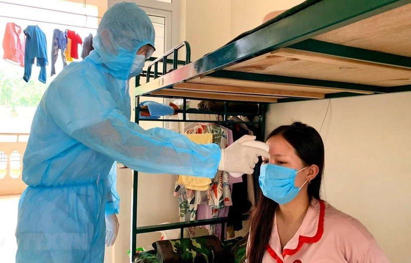 Đo thân nhiệt cho người dân trong khu cách ly. 