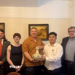 Phó giáo sư, tiến sỹ Phạm Minh Tuấn, Phó Tổng biên tập Tạp chí Cộng sản tặng quà lưu niệm lãnh đạo Đảng Cộng sản Anh. (Ảnh: TTXVN phát).
