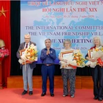 Thừa ủy quyền của Chủ tịch nước, Thượng tướng Phạm Hồng Hương trao tặng Huân chương Hữu nghị cho các thành viên của Ủy ban quốc tế về Làng Hữu nghị Việt Nam. (Nguồn: Đại đoàn kết)