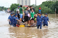 Cảnh sát biển hỗ trợ người dân di chuyển qua vùng ngập sâu khu vực cầu Ngà 