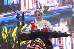 Nghệ sỹ ban nhạc Sar Afshan trình diễn với đàn Qanun, một nhạc cụ truyền thống của Iran có nhiều điểm tương đồng với đàn Tam thập lục tại Việt Nam. (Ảnh: Minh Anh/Vietnam+)