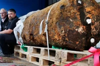 Hai chuyên gia xử lý bom mìn ngồi bên cạnh quả bom nặng 1,8 tấn thời Thế chiến 2, ngay sau khi họ vô hiệu hóa nó, tại Frankfurt, Đức năm 2017. (Nguồn: AP)