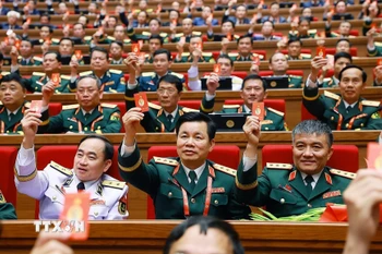 Đại biểu biểu quyết thông qua Nghị quyết Đại hội XIV của Đảng. (Ảnh: TTXVN)