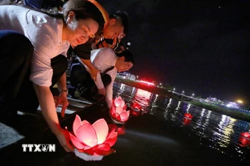 Các đại biểu thả đèn hoa đăng trên sông Đà. (Ảnh: Trọng Đạt/TTXVN)