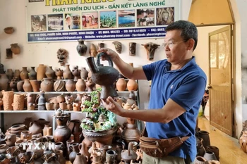 Du khách tìm hiểu sản phẩm gốm tại Hợp tác xã gốm Chăm Bàu Trúc (huyện Ninh Phước, Ninh Thuận). (Ảnh: Nguyễn Thành/TTXVN)