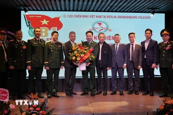 Đại sứ Nguyễn Đắc Thành tặng hoa chúc mừng Hội Cựu hiến binh Việt Nam tại Berlin- Brandenburg. (Ảnh: Thu Hằng /TTXVN)
