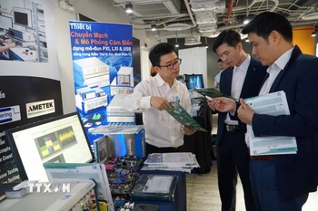 Các đại biểu tham quan triển lãm, giới thiệu các giải pháp phát triển công nghiệp bán dẫn, điện tử. (Ảnh: Thu Hoài/TTXVN)