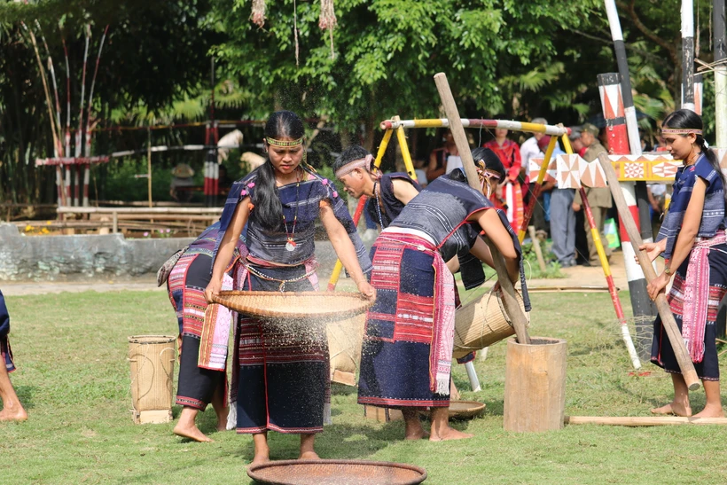 Cô gái Bana sàng gạo trong lễ mừng lúa mới của người Bana. (Ảnh: Vũ Văn Mừng)