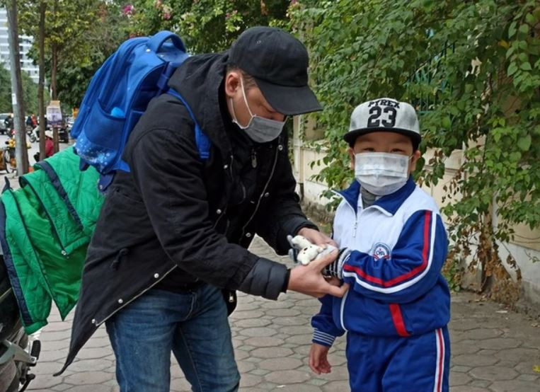 Phụ huynh cần mặc ấm cho con trong ngày giá rét. (Ảnh: Phạm Mai/Vietnam+)