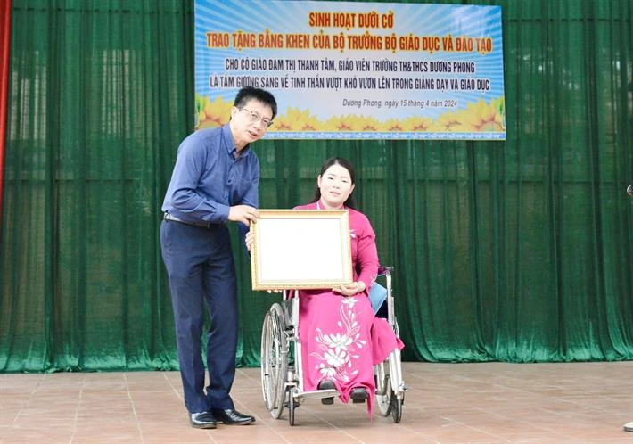 Chủ tịch Công đoàn Giáo dục Việt Nam Nguyễn Ngọc Ân trao Bằng khen của Bộ trưởng Bộ GDĐT cho cô giáo Đàm Thị Thanh Tâm. (Ảnh: Bộ GD-ĐT)