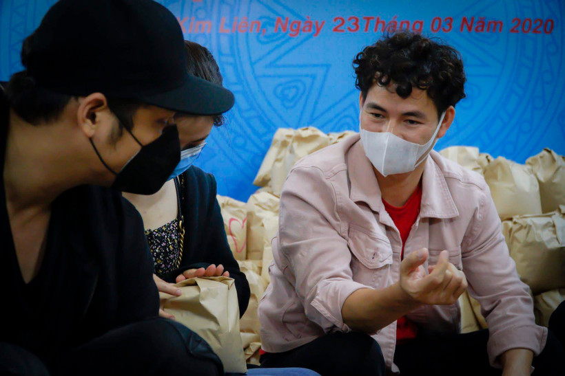 Nghệ sỹ Xuân Bắc cùng các diễn viên trẻ tham gia đóng gói những phần quà gửi tặng người khó khăn trong dịch bệnh. (Ảnh: Minh Hiếu/Vietnam+)