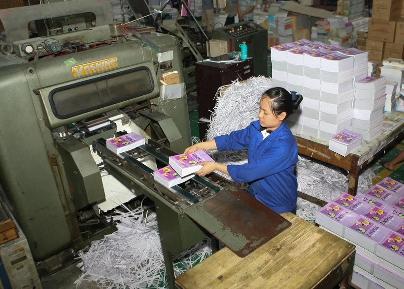 Hoàn thiện ấn phẩm sách giáo khoa trước khi bán ra thị trường. (Ảnh: TTXVN)