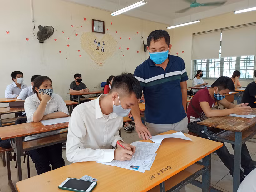 Thí sinh và giám thị phải đeo khẩu trang phòng dịch trong kỳ thi Tốt nghiệp Trung học phổ thông 2020. (Ảnh: Phạm Mai/Vietnam+)