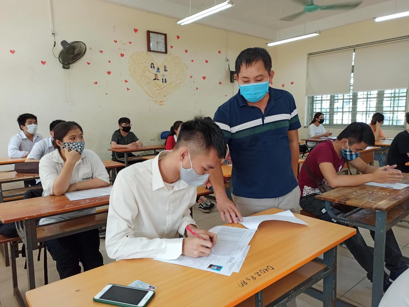 Thí sinh và giám thị phải đeo khẩu trang phòng dịch trong kỳ thi Tốt nghiệp Trung học phổ thông 2020. (Ảnh: Phạm Mai/Vietnam+)