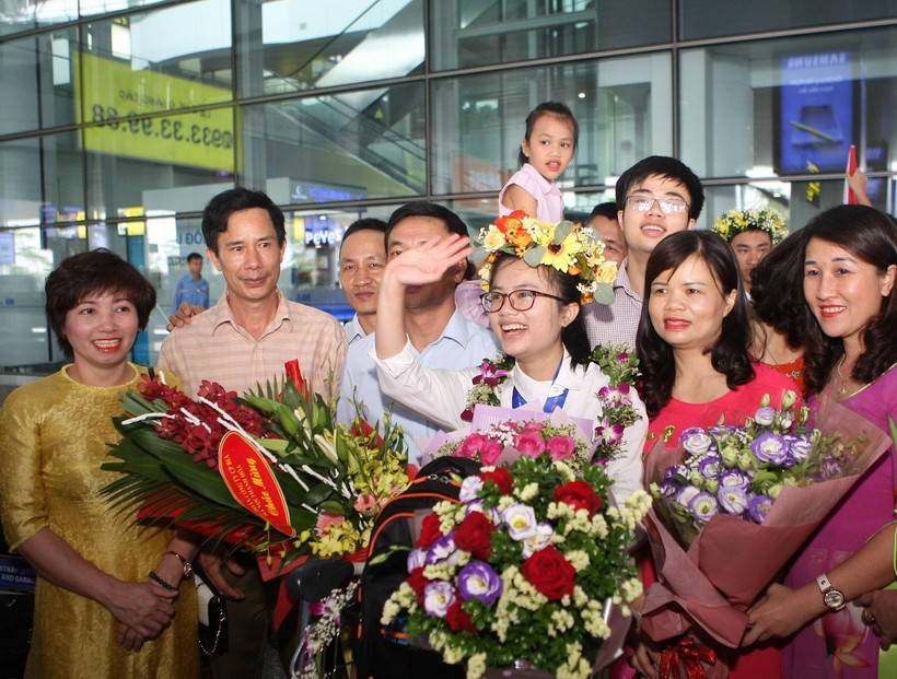Nguyễn Khánh Linh cười tươi giữa bạn bè, thầy cô và người thân đi đón tại sân bay Nội Bài. (Ảnh: Thanh Tùng) 