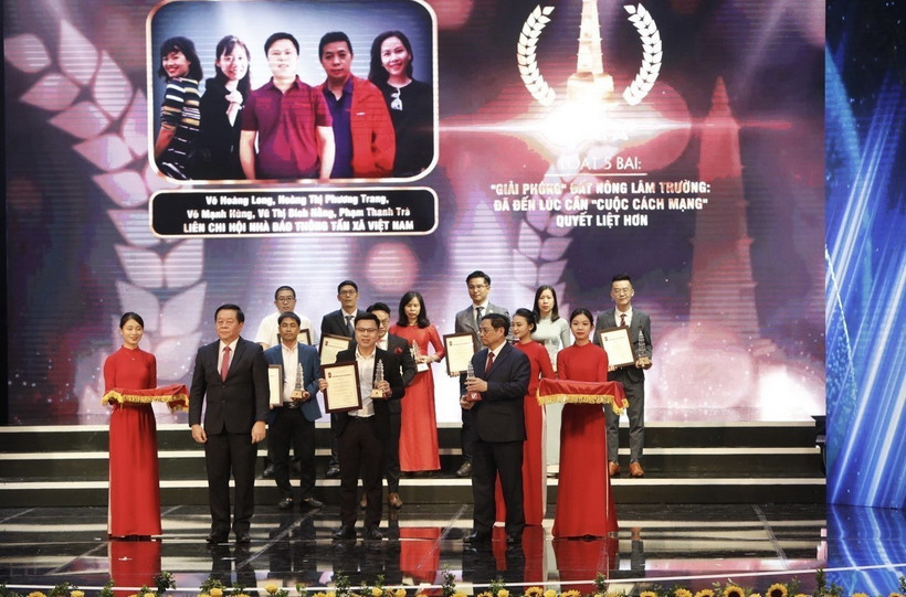 Thủ tướng Phạm Minh Chính và Bí thư Trung ương Đảng, Trưởng Ban Tuyên giáo Trung ương Nguyễn Trọng Nghĩa trao giải A cho các tác giả đạt Giải Báo chí Quốc gia lần thứ XVI . (Ảnh: Trần Việt/TTXVN)