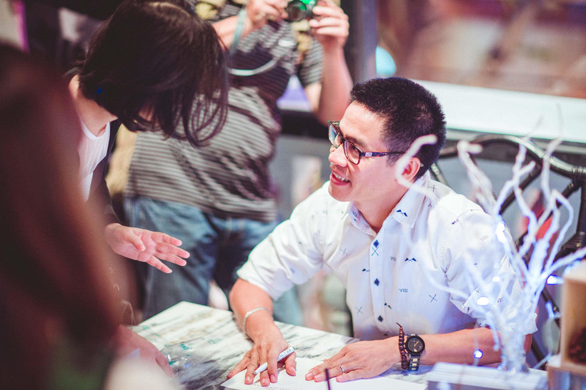 Nhà thơ Phong Việt ký tặng sách cho độc giả. (Ảnh: NVCC)