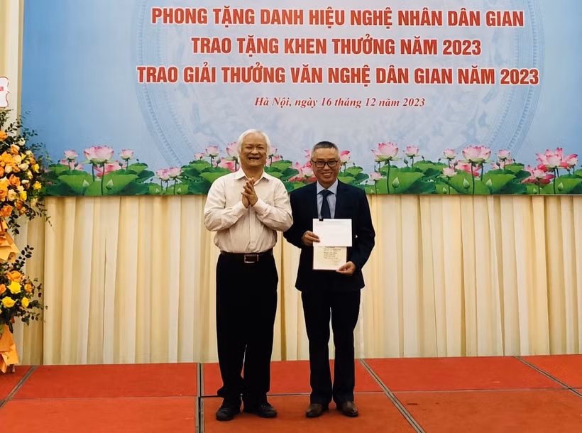 Giáo sư, Tiến sỹ Lê Hồng Lý, Chủ tịch Hội Văn nghệ Dân gian Việt Nam trao Giải Nhì A (không có Giải Nhất) cho tác giả Nguyễn Tiến Dũng. (Ảnh: Phương Hà/TTXVN)