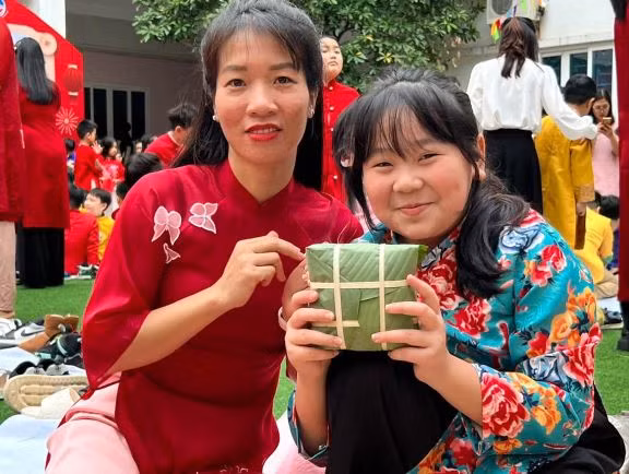 Học sinh Trường Trung học Cơ sở - Trung học Phổ thông Newton cơ sở 1 tự tay gói bánh dành tặng các bạn nhỏ Làng trẻ Hòa Bình. (Ảnh: PV/Vietnam+)
