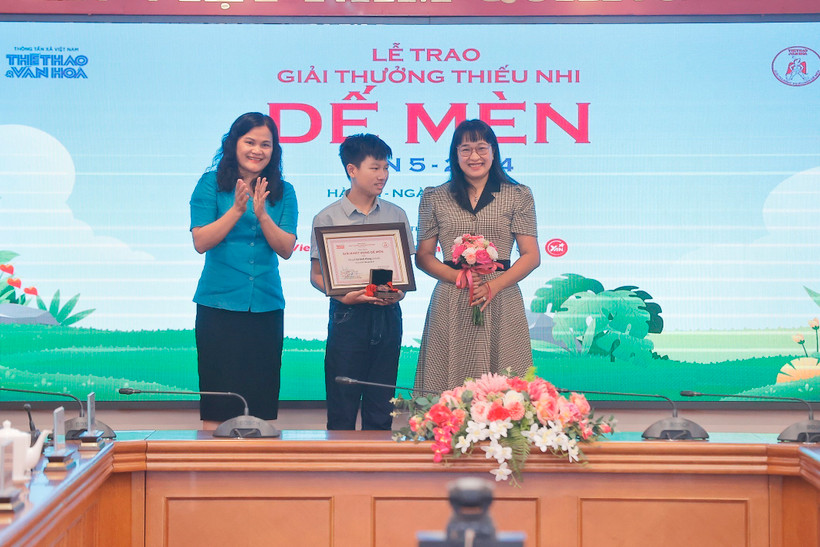 Phó Tổng giám đốc Thông tấn xã Việt Nam Nguyễn Thị Sự (trái) trao giải Khát vọng Dế Mèn cho tác giả Lê Sinh Hùng (giữa). (Ảnh: Minh Quyết/TTXVN)