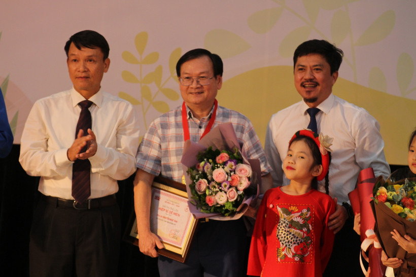Ủy viên Ban Chấp hành Trung ương Đảng, Tổng Giám đốc TTXVN Nguyễn Đức Lợi (trái) và ông Lê Xuân Thành, Tổng biên tập Báo Thể thao và Văn hóa trao giải "Hiệp sĩ Dế Mèn" cho nhà văn Nguyễn Nhật Ánh. (Ảnh: Minh Anh/Vietnam+)