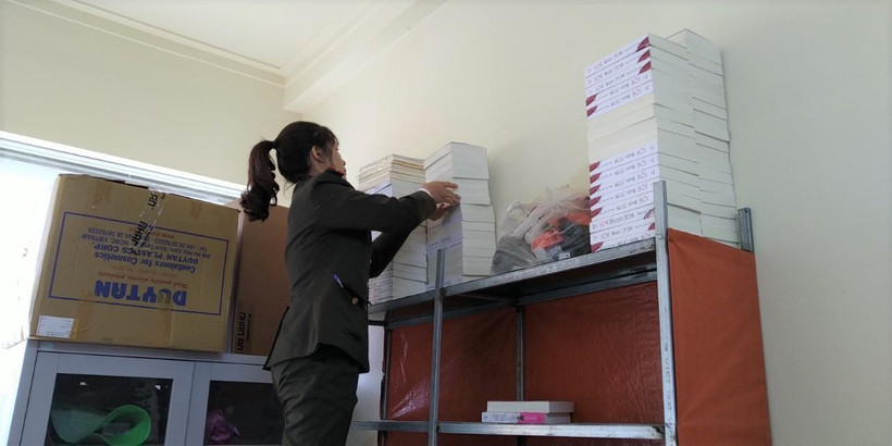 Một cán bộ chuẩn bị niêm phong sách lậu tại cơ sở ngõ 89 Ngô Thì Sỹ, Hà Đông. (Ảnh: Minh Thu/Vietnam+)