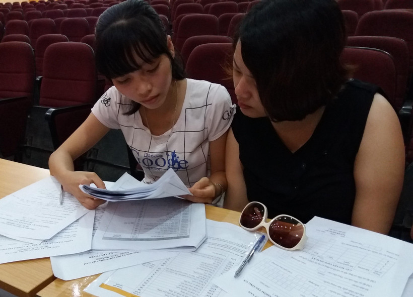 Thí sinh, phụ huynh tìm hiểu thông tin về thủ tục nhập học. (Ảnh: Phạm Mai/Vietnam+)