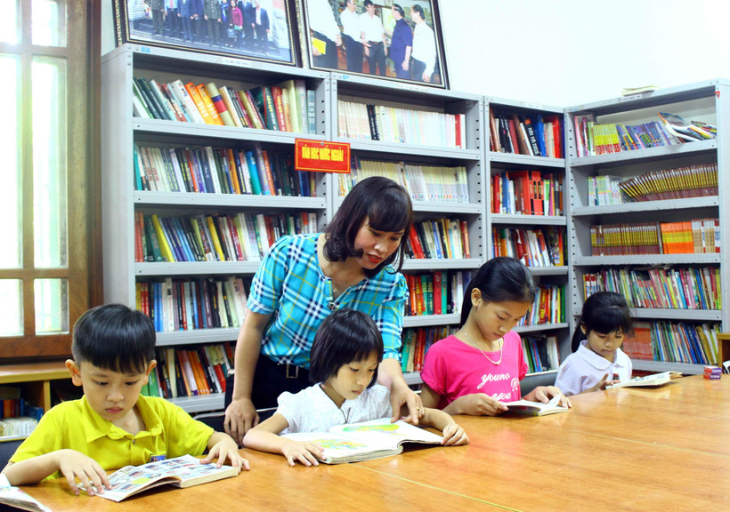 Các em học sinh chăm chú đọc sách tại thư viện Làng Sen. (Ảnh: Tá Chuyên/TTXVN)