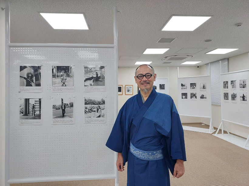 Nhiếp ảnh gia Nhật Bản Nobukata Koremoto bên các tác phẩm của mình. (Ảnh: Minh Thu/Vietnam+)