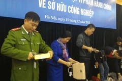 Cắt bỏ sản phẩm giả mạo. (Ảnh: T.H/Vietnam+) 