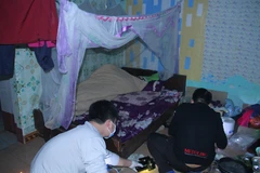 Lực lượng chức năng khám nghiệm hiện trường, nơi phát hiện thi thể nạn nhân. (Ảnh: TTXVN phát)