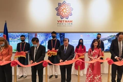 Ban Tổ chức Việt Nam và khách mời cắt băng khai trương Nhà triển lãm Việt Nam. (Ảnh: TTXVN phát)