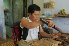 Hội viên Lê Viết Luận, người khuyết tật, người thầy truyền nghề chạm khắc cho các hội viên Hội Người khuyết tật huyện Diên Khánh, Khánh Hòa. (Ảnh: Phan Sáu/TTXVN)