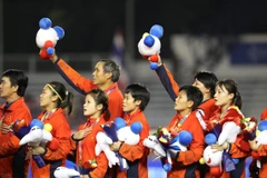 Đội tuyển nữ Việt Nam hát Quốc ca trên bục nhận huy chương. (Ảnh: Hoàng Linh/TTXVN)