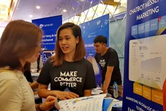 Các đại biểu tham quan và tìm hiểu sản phẩm, dịch vụ cung ứng tại các gian hàng giới thiệu xu hướng ứng dụng công nghệ trong tiếp thị. (Ảnh: Thế Anh/TTXVN)